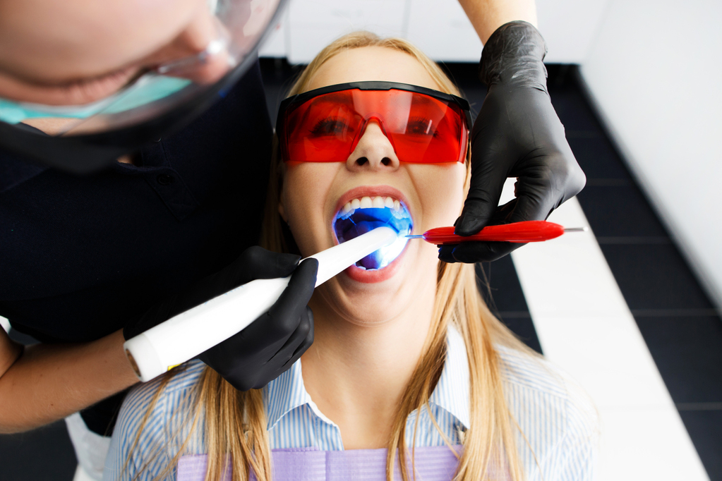 patient-red-glasses-sits-chair-dentist-office-while-doctor-whiten-her-teeth.jpg