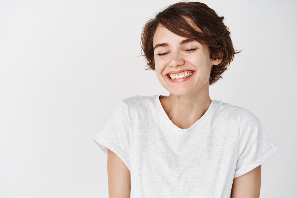 portrait-happy-positive-woman-close-eyes-smiling-carefree-standing-t-shirt-white-wall.jpg