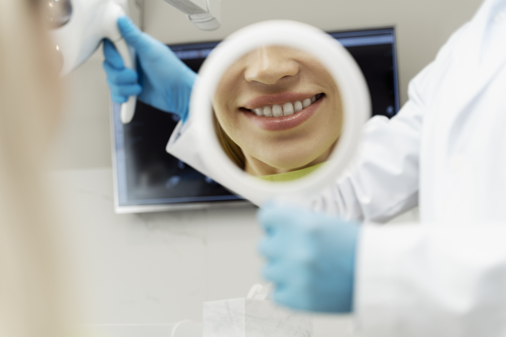 portrait-female-patient-with-toothy-smile-looking-mirror-after-dental-treatment.jpg