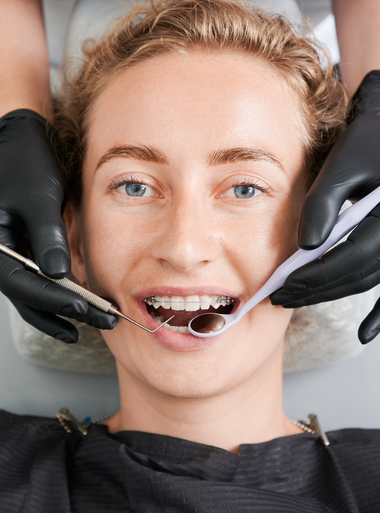 dentist-examining-woman-teeth-with-braces.jpg